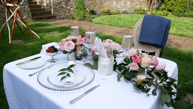 Decorating a Festive table open air. Wedding Table Decoration with Bouquets of Natural Fresh Flowers for a Family Feast