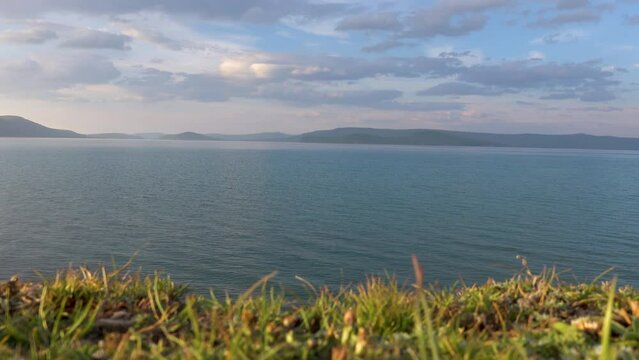 Majestic view of lake Khovsgol with beautiful mountains in the background. Blue water edge with the misty looking sky in the horizon.