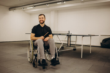 A boy in a wheelchair plays table tennis.