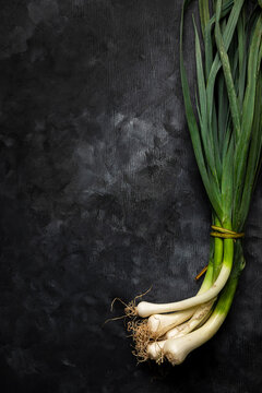 Bunch of leeks over black background.