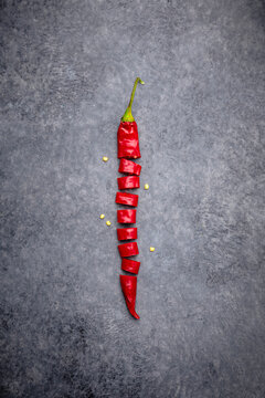 Cut chilli pepper over gray background