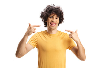 Guy with curly hair pointing at his white teeth