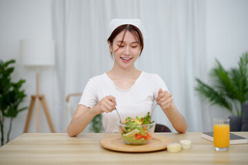 Portrait of happy playful asian girl eating fresh salad in diet concept