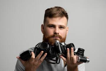 Close up portrait of man holding a old vintage film cameras.