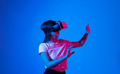 Woman wearing a VR headset and interacting with virtual reality. Simulation, future technology, AR and metaverse concept.