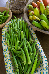 Bunches of banana and okra in rustic and decorated wooden bowls for sale after harvest in a popular economy farm. Sao Paulo state, Brazil