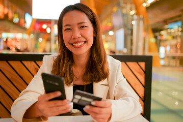 close up asian business woman holding smartphone with credit card for pay online shopping e-commerce concept