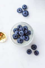 Homemade yogurt with blueberries. Top view on the white table