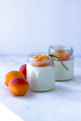 Homemade yogurt with juicy apricots. Yogurt on a white table. Side view