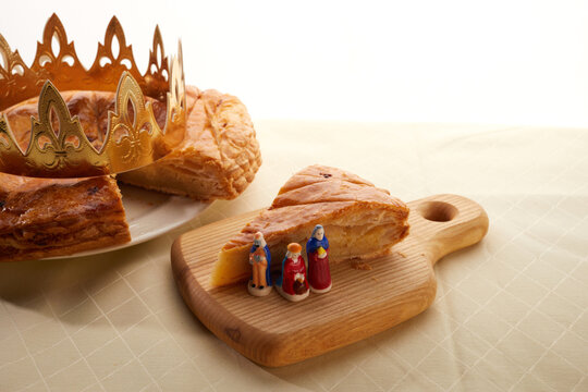 King cake or galette des rois in French. Epiphany pie with golden paper crown and little ceramic figurine