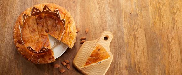 King cake or galette des rois in French. Epiphany pie with golden paper crown 