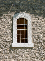 Vintage window with massive white stone blocks frame front view