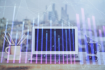 Stock market graph on background with desk and personal computer. Double exposure. Concept of financial analysis.