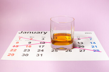 Abstinence from alcohol in January, calendar with a glass of whiskey - obrazy, fototapety, plakaty