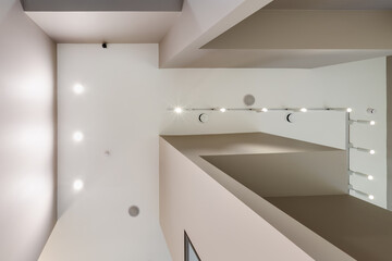 suspended ceiling with halogen spots lamps and drywall construction in empty room in apartment or...