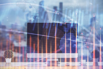 Stock market graph on background with desk and personal computer. Multi exposure. Concept of financial analysis.