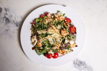 top view salad with shrimp and tomatoes, cheese and herbs on a plate in a restaurant