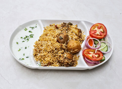 sindhi chicken biryani or chicken pulao with raita and salad served in plate isolated on table top view of indian and pakistani spicy food