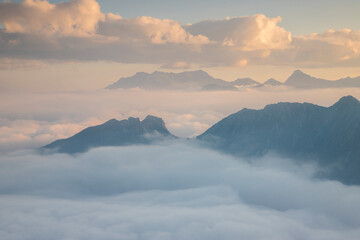 Fototapeta na wymiar the Peaks of the mountains in the Adamello park emerge from the clouds at dawn, from Pizzo Badile Camuno peak, Valle Camonica, Lombardy, Italy.