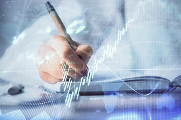 Plakat Multi exposure of woman's hands making notes with forex graph hologram. Concept stock market analysis.