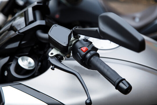 Closeup motorcycle handlebar with reversing empty mirror, copy space