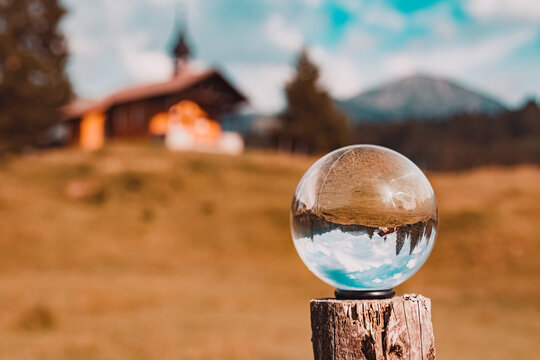 Crystal ball alpine landscape shot with the famous Brother Klaus Chapel, Waeldele, Kleinwalsertal valley, Riezlern, Vorarlberg, Austria