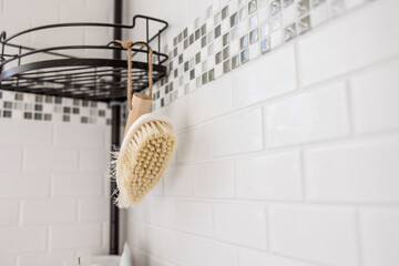 Bamboo shower cleaning brush hanging in shower