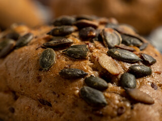 Dark buns on a wooden background. Bakery products with grains.