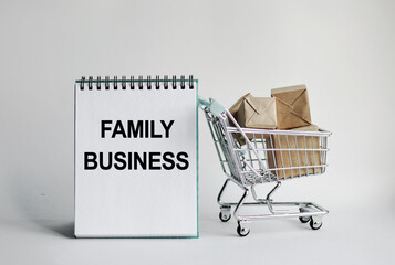 A notebook with the inscription Family Business. With a decorative grocery cart along with small...