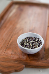 Blue popcorn kernels in white bowl on wood background, healthy snack, popcorn kernels, healthy eating
