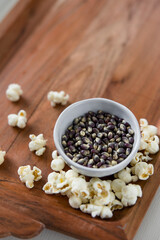 Blue popcorn kernels in white bowl on wood background, healthy snack, popcorn kernels, healthy eating