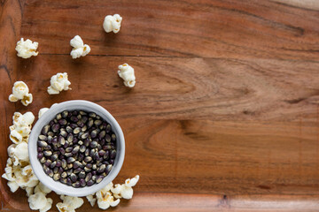 Blue popcorn kernels in white bowl on wood background, healthy snack, popcorn kernels, healthy eating, copy space