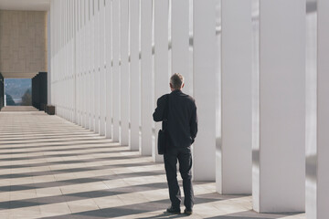 Businessman in front of large corporate building