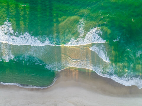 Aerial view of waves breaking on the shoreline at Booti Booti beach, Wallis Lake, New South Wales, Australia.