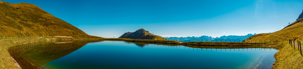 Obraz premium High resolution stitched panorama with reflections in a lake at the famous Kanzelwand summit, Riezlern, Vorarlberg, Austria