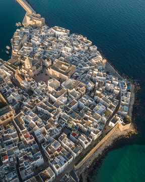 Aerial view of Monopoli old town at sunset along the Mediterranean Sea, Bari, Puglia, Italy.