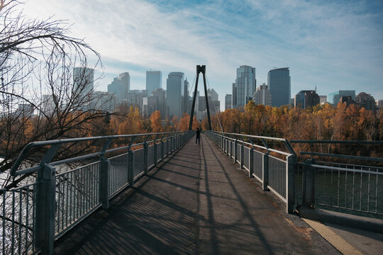 Man on the footbridge taking photos of the city of Calgary in Alberta, Canada.
