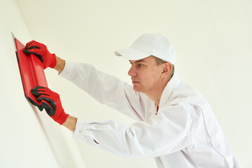 Plasterwork and wall painting preparation. craftsman applying plaster or filling