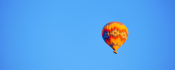 Fototapeta premium Flying hot air balloon against bright blue sky
