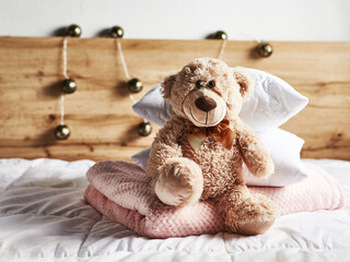 Cute vintage Teddy Bear on bed
