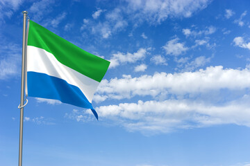 Republic of Sierra Leone Flag Over Blue Sky Background. 3D Illustration