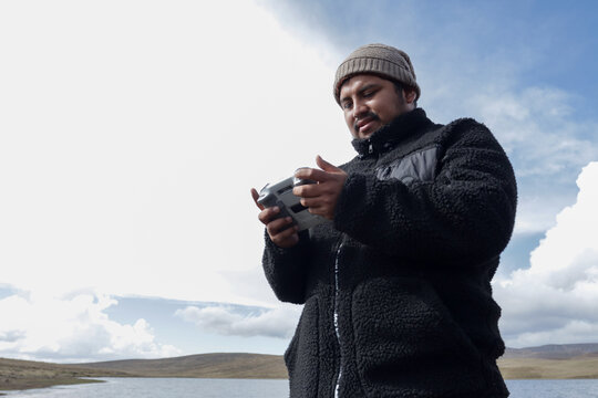 Tourist man with a drone remote control on a mountain in South America. Drones concept, tourism, drone pilot.