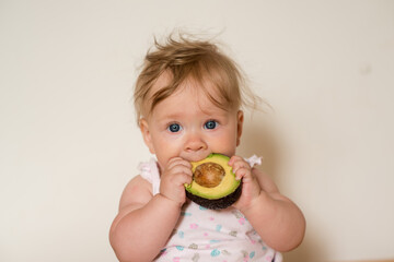 Little child eats an avocado