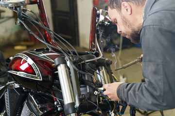 Obraz premium Electrician soldering electrical wires to electrical equipment.