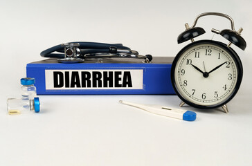 On a white surface, a thermometer, a stethoscope and a folder with the inscription - Diarrhea