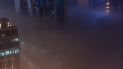 Buildings are covered in thick layer of fog in Business Bay night timelapse.