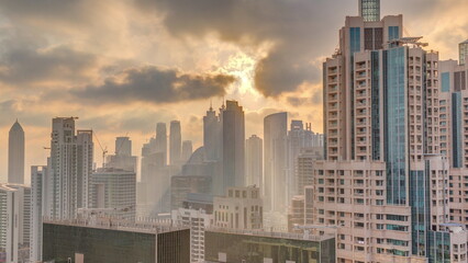 Fototapeta na wymiar Dubai skyscrapers with golden sunset over business bay district timelapse.