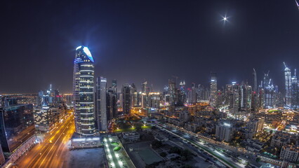 Fototapeta na wymiar Dubai's business bay towers aerial all night timelapse. Rooftop view of some skyscrapers