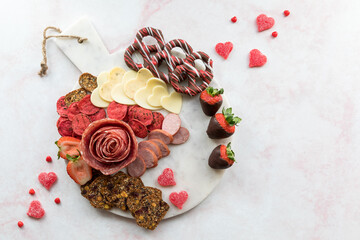 A Valentine's Day charcuterie arrangement on a white marble slab.