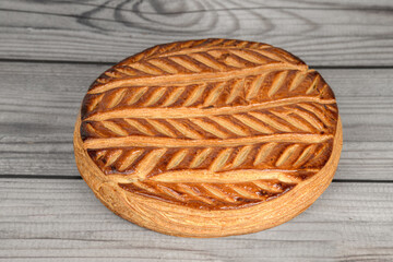 Galette des roi artisanale à la frangipane sur fond de bois